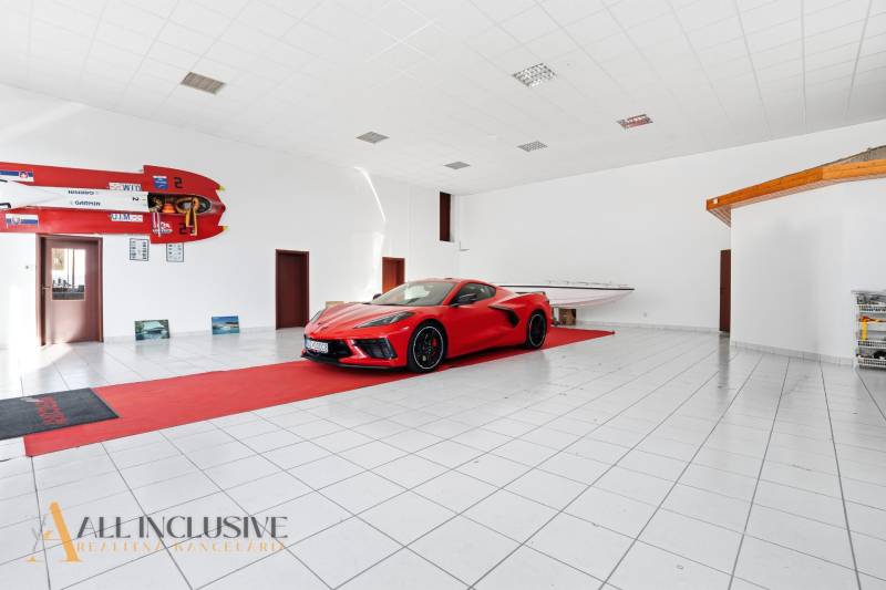 Obchodní prostory zobrazují auto a loď s bílou podlahou a sportovním příslušenstvím.