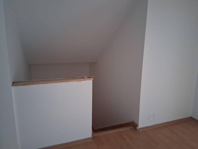 Schodiště v rodinném domě s podlahou s dřevěným dekorem.