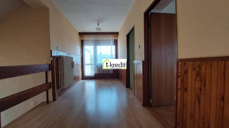 Chodba v rodinném domě s podlahou s dřevěným dekorem a obloženími ze dřeva.