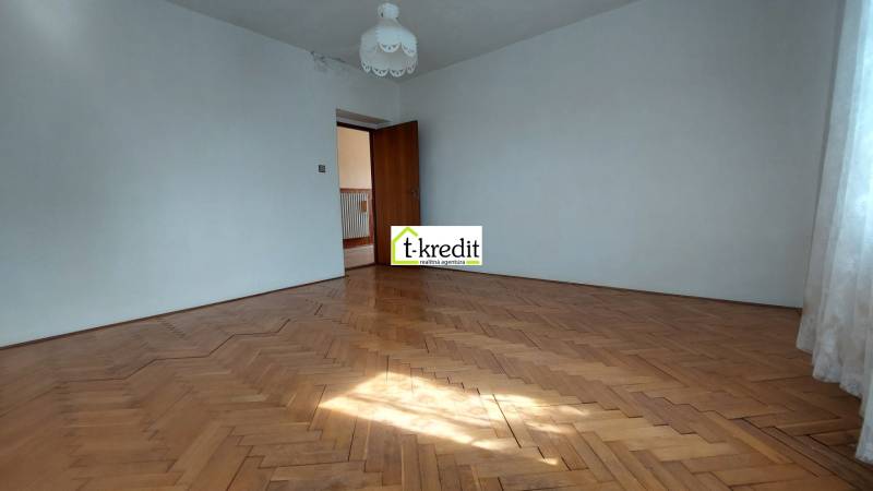 Prostorný pokoj s podlahou s dřevěným dekorem v rodinném domě.