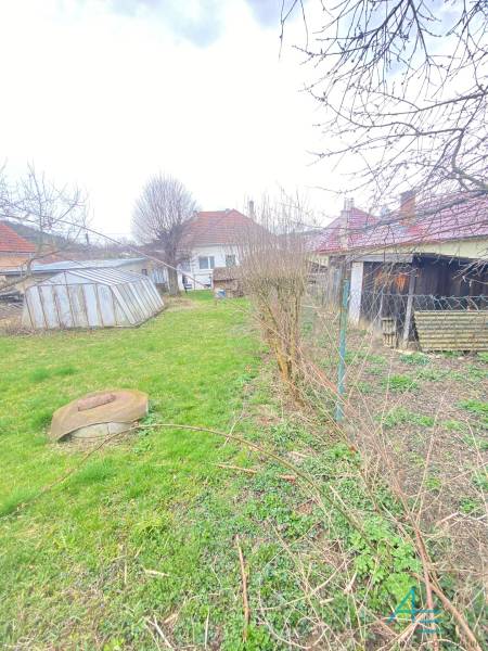 Zahrada u rodinného domu na Turej Lúce v Myjavě s trávníkem a přístřešky.