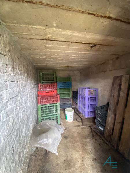 Skladovací prostor v rodinném domě obsahuje plastové bedny a kbelík.