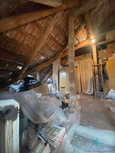 Podkroví rodinného domu se střešní konstrukcí a uskladněnými předměty pod střechou.