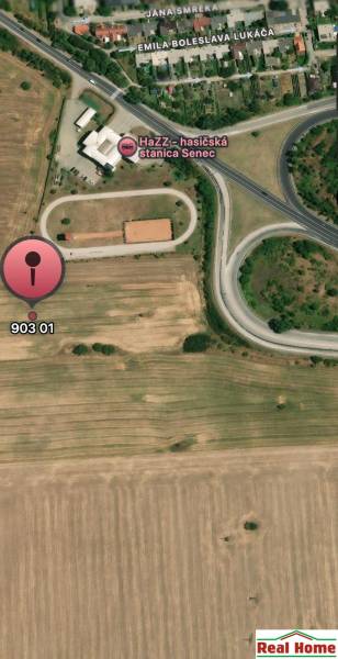 Letecký pohled na developerské pozemky v Senci s dopravní infrastrukturou v okolí.