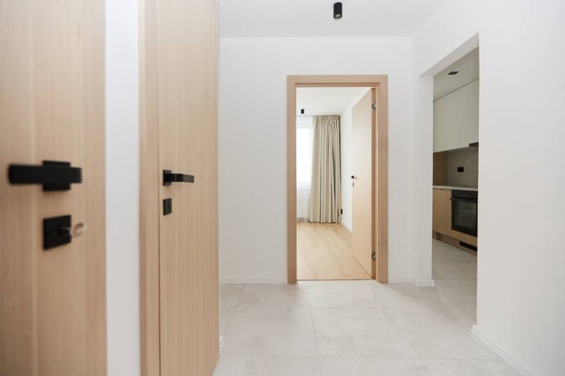 Světlá předsíň s podlahou v dekoru dřeva v 3-pokojovém bytě.