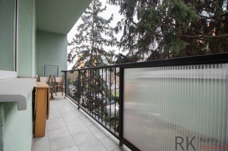 Balkon 3-pokojového bytu s nábytkem a zábradlím, výhled do zeleně.