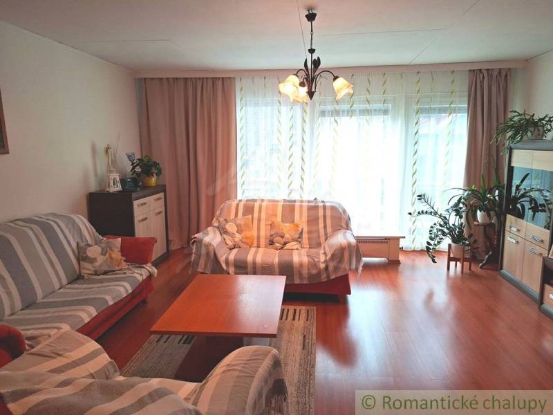 Obývací pokoj v rodinném domě s podlahou s dřevěným dekorem, světlem a pohovkami.
