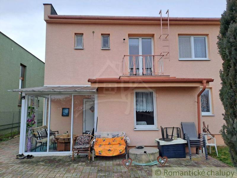 Rodinný dům ve Velkých Ripňanech se zasklenou terasou a dlážděným dvorem.