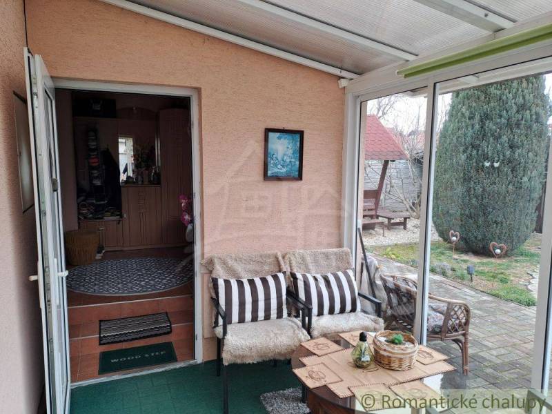 Zimní zahrada v rodinném domě s pohodlným posezením a výhledem do zahrady.