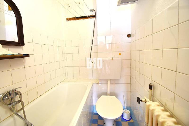 Koupelna v rodinném domě s vanou, toaletou a obkládanými stěnami.