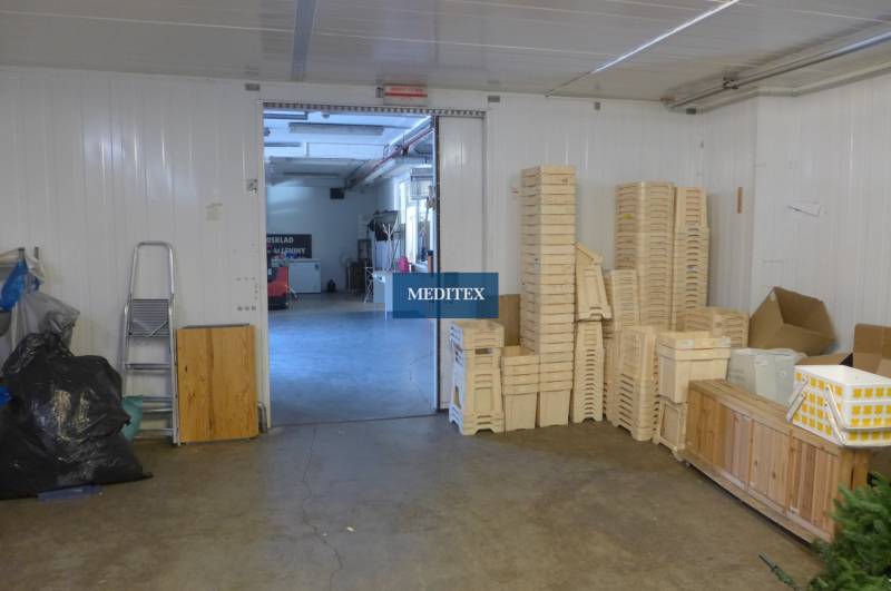 Interiér skladu s dřevěnými přepravkami a žebříkem, vhodný pro sklady a haly.