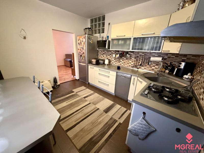 Kuchyně ve 3-pokojovém bytě s plynovou varnou deskou a kachličkovým obkladem.