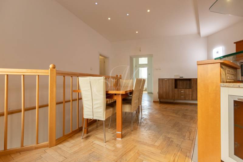 Jídelní kout ve 4-pokojovém bytě s podlahou s dřevěným dekorem a jídelním stolem.