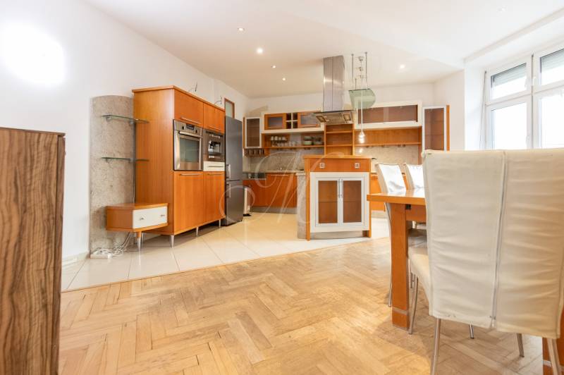 Kuchyně ve 4-pokojovém bytě s podlahou s dřevěným dekorem a vestavěnými spotřebiči.