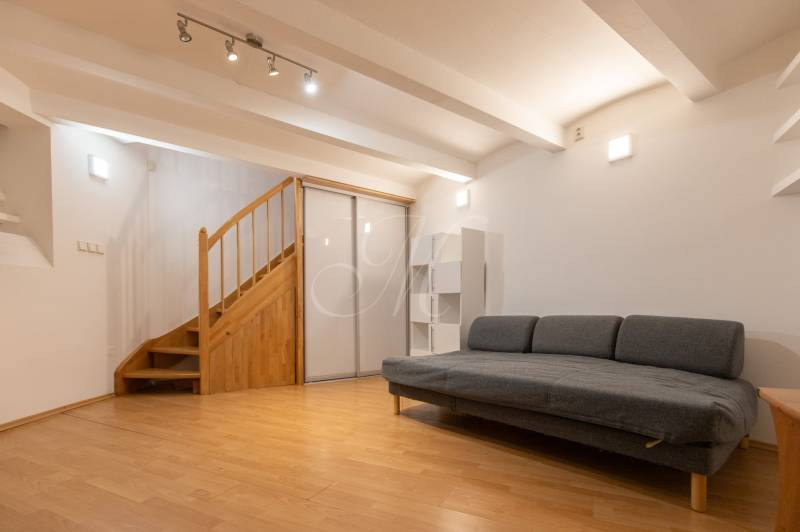 Obývací pokoj s pohovkou a schodištěm, podlaha s dřevěným dekorem, 4pokojový byt.