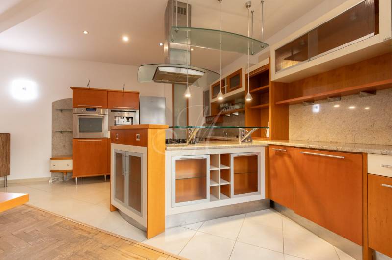 Kuchyně ve 4-pokojovém bytě s ostrůvkem a podlahou s dřevěným dekorem.