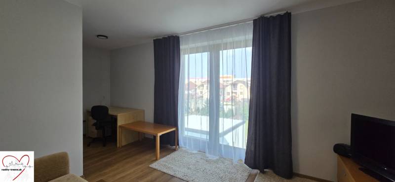 Obývací pokoj se stolem a podlahou s dřevěným dekorem ve 3-pokojovém bytě.