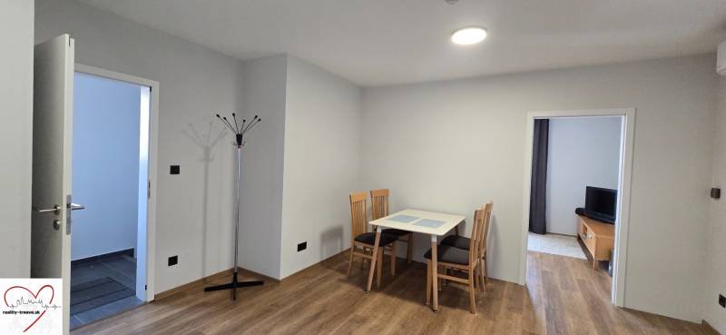 Jídelní kout se stolem a židlemi, podlaha s dřevěným dekorem v 3-pokojovém bytě.