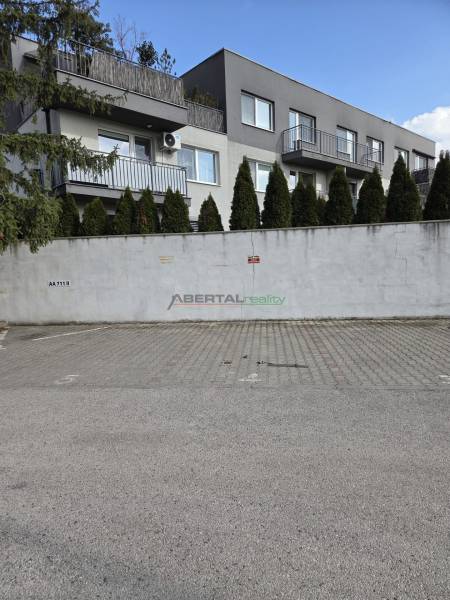 Řadové domy na Vavřínové v Bratislavě-Ružinově s parkovací plochou před vstupem do garáží.