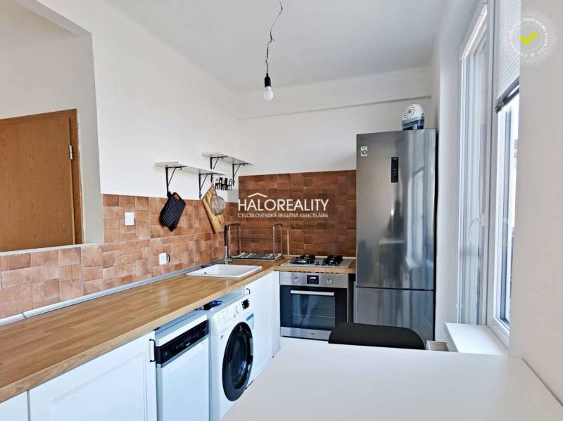 Kuchyně ve 3-pokojovém bytě s podlahou s dřevěným dekorem a spotřebiči.