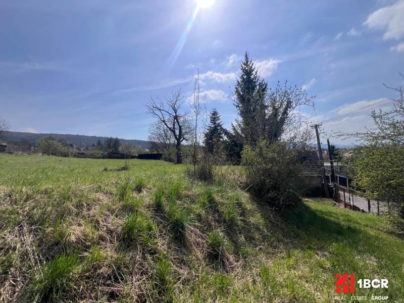 Pozemky - bydlení na Budovatelské v Mariance, svažitá zelená plocha s výhledem.