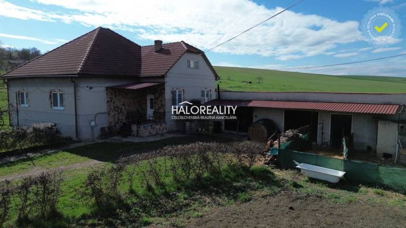 Rodinný dům v Rimavských Janovcích, s červenou střechou a rozlehlou zahradou.