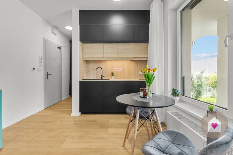 Kuchyně s šedými skříňkami a podlahou s dřevěným dekorem v 1-pokojovém bytě.