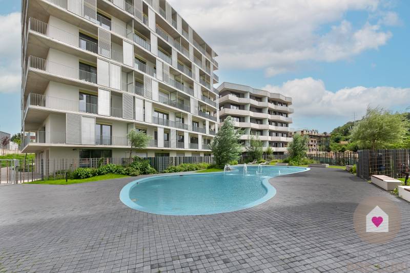 Součástí rezidenční oblasti na Poliankách v Bratislavě-Dúbravce je bazén a moderní architektura bytovky.
