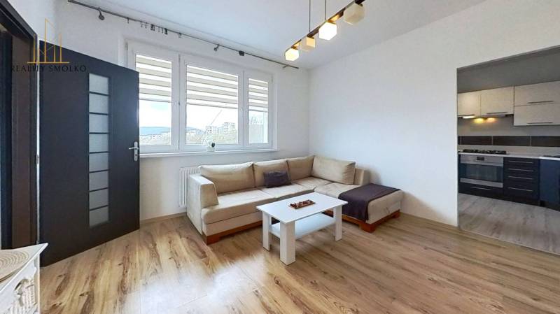 Obývací pokoj s pohovkou a podlahou s dřevěným dekorem ve 3-pokojovém bytě.