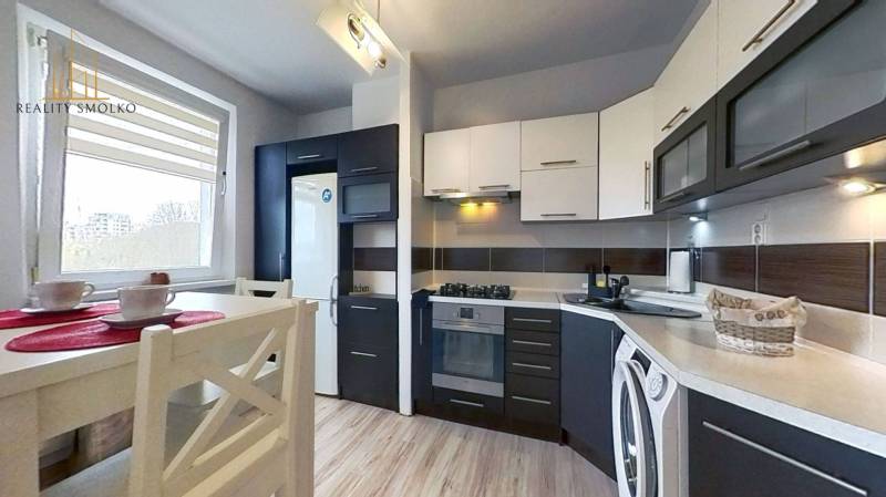 Kuchyně v 3-pokojovém bytě s linkou a spotřebiči, podlaha s dřevěným dekorem.