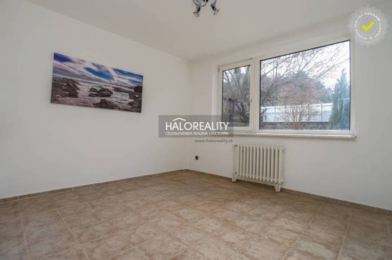 Prostorný pokoj s oknem a radiátorem v rodinném domě.