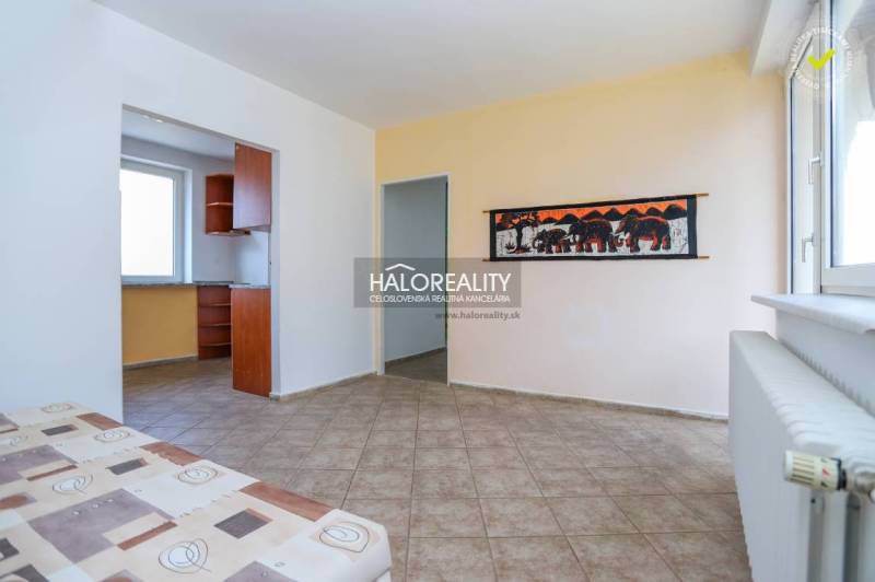 Interiér rodinného domu s kachličkovou podlahou, obrazem slonů a výhledem do kuchyně.