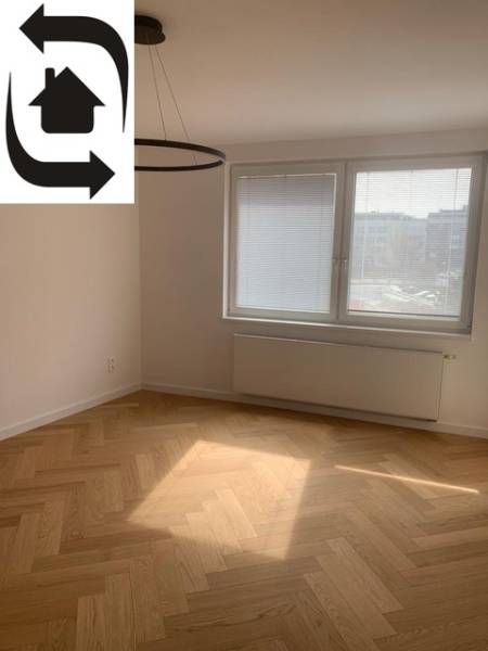 Světlý pokoj s podlahou s dřevěným dekorem v 2-pokojovém bytě, velké okno.