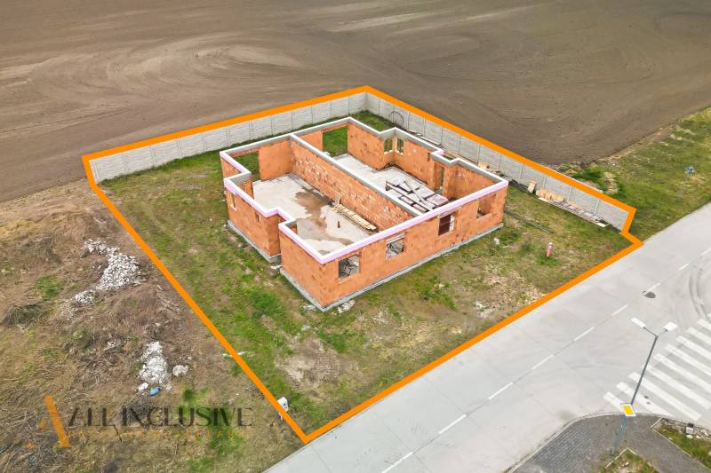 Rozestavěný rodinný dům ve Velkých Dvorníkách, ohraničený oranžovou čarou, situovaný u cesty.