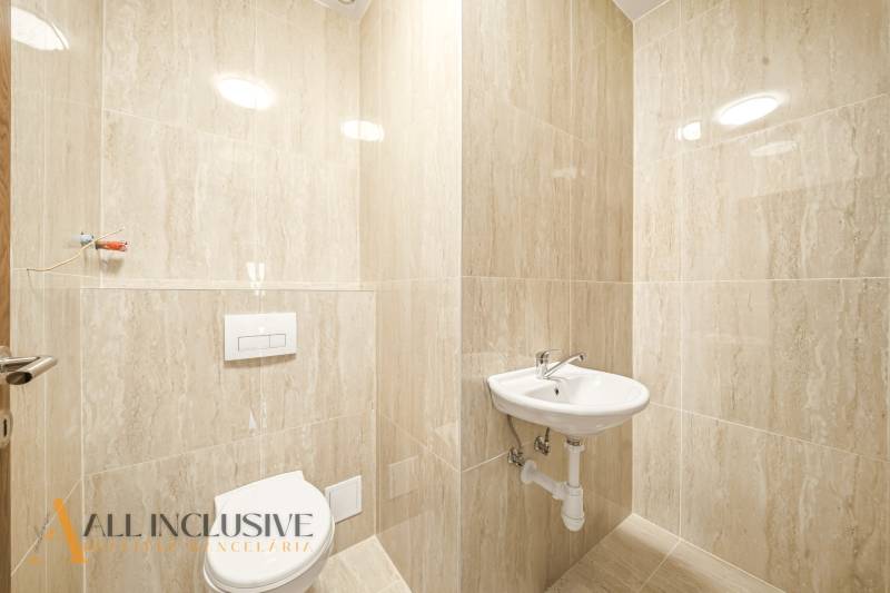 Koupelna v rodinném domě s bílým umyvadlem a toaletou.