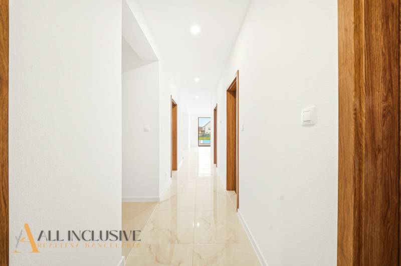 Interiér rodinného domu se světlými stěnami a gresovou podlahou.