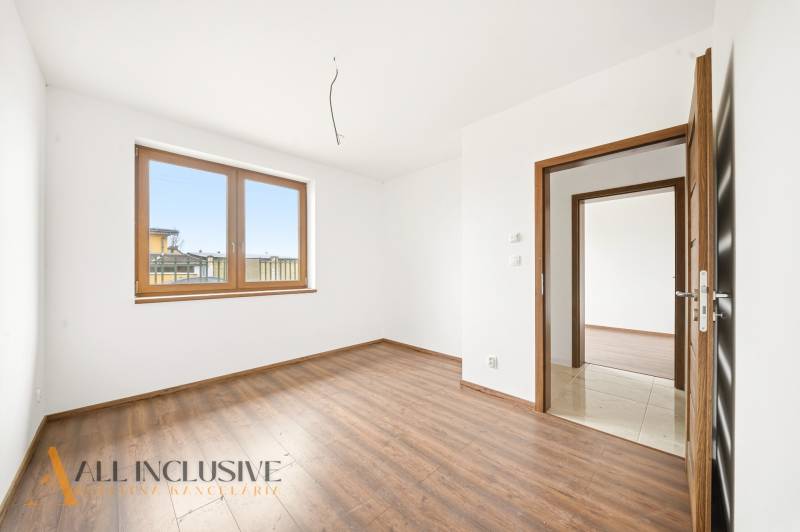 Interiér s podlahou s dřevěným dekorem, velkým oknem a dveřmi v rodinném domě.