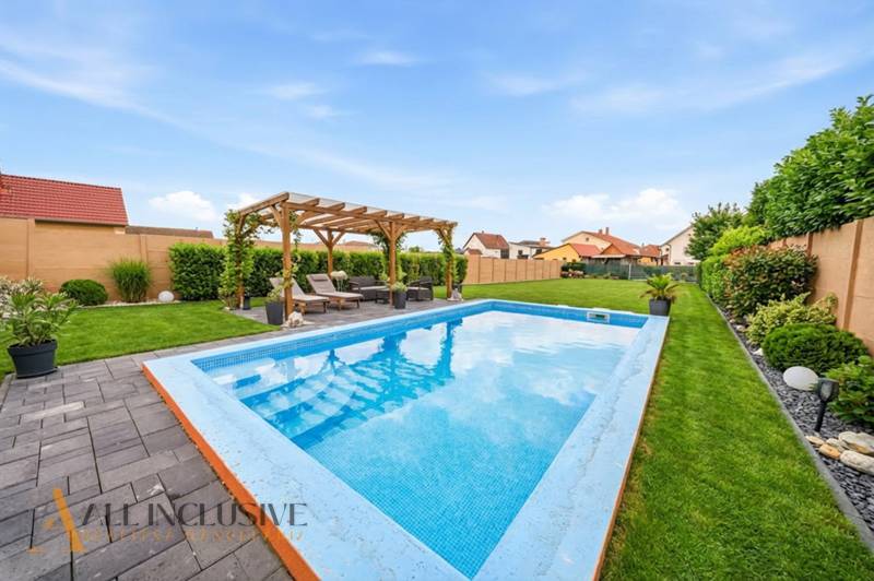 Rodinný dům v Horním Mýtě: Bazén, pergola a upravená zahrada na zahradě.