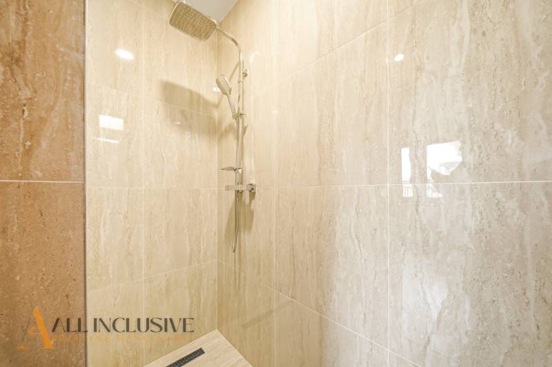 Sprchový kout v rodinném domě s mramorovým obkladem.