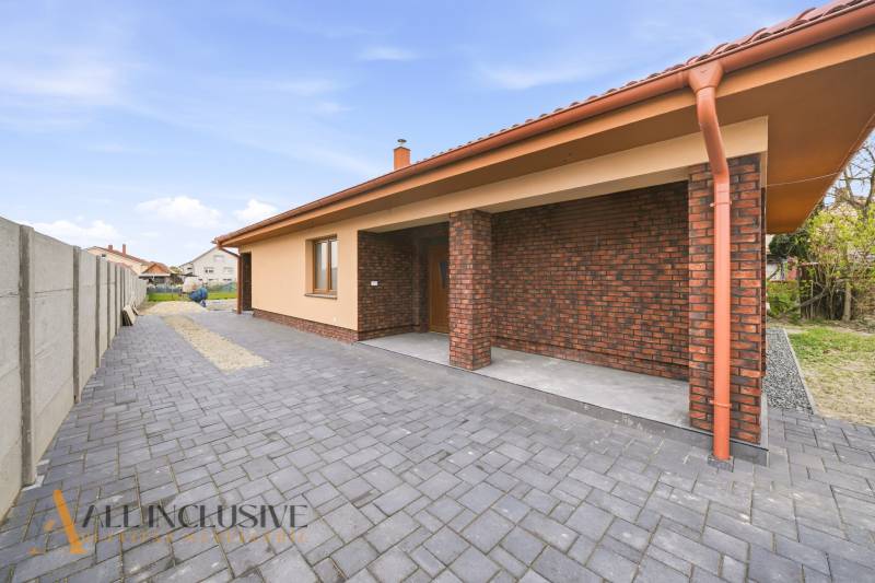 Rodinný dům v Horním Mýtě s cihlovou fasádou a dlážděným dvorem.