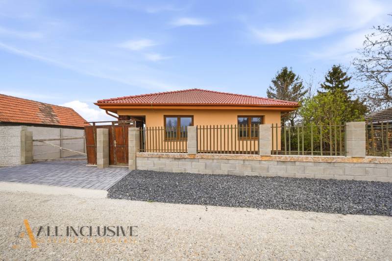 Rodinný dům v Horním Mýtě má oranžovou fasádu a červenou střechu.