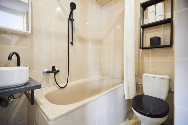 Koupelna s vanou, umyvadlem, sprchou a toaletou v 2-pokojovém bytě.