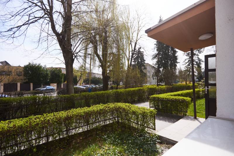 Zahrada s chodníkem a zaparkovaná auta na Lomnické ulici v Košicích, městská část Sever.