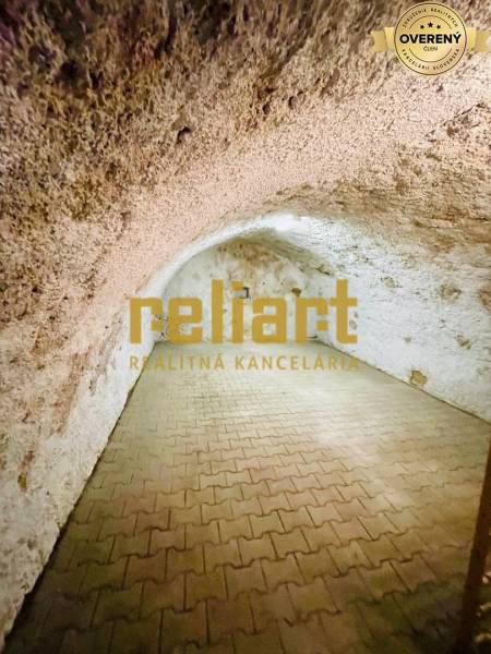 Sklep s cihlovou podlahou v rodinném domě.