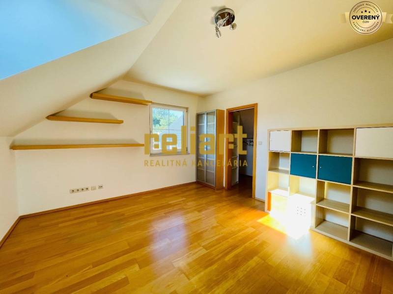 Pokoj v rodinném domě s podlahou s dřevěným dekorem, policemi a policovou skříní.