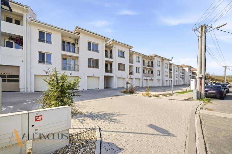 Komplex bílých budov a parkovacích míst v Dunajské Stredě, ideální pro 4pokojový byt.