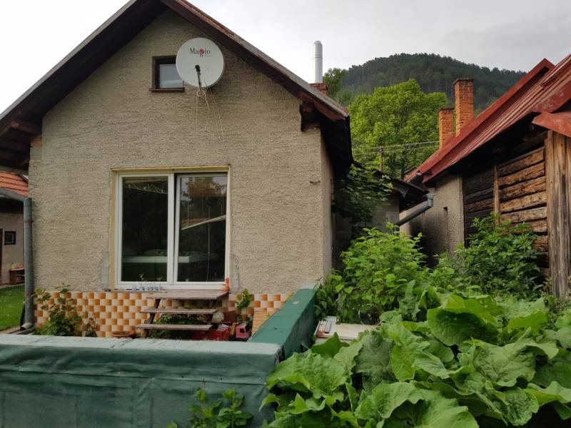 Rodinný dům v Blatnici na Blatnici s dřevěnými prvky a zahradou obklopenou zelení.