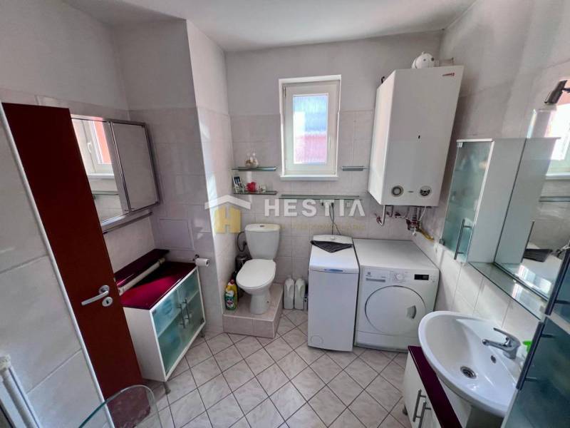 Koupelna obsahuje pračku, skříňky, WC a umyvadlo, vhodná pro 1-pokojový byt.