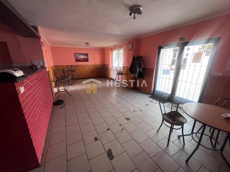 Kavárna s cihlovou stěnou a prázdnými židlemi, gastro prostory.