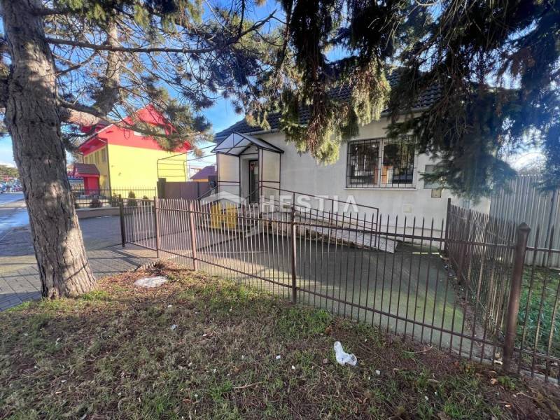 Starší dům obklopený plotem a stromy blízko gastro prostorů v Senici.